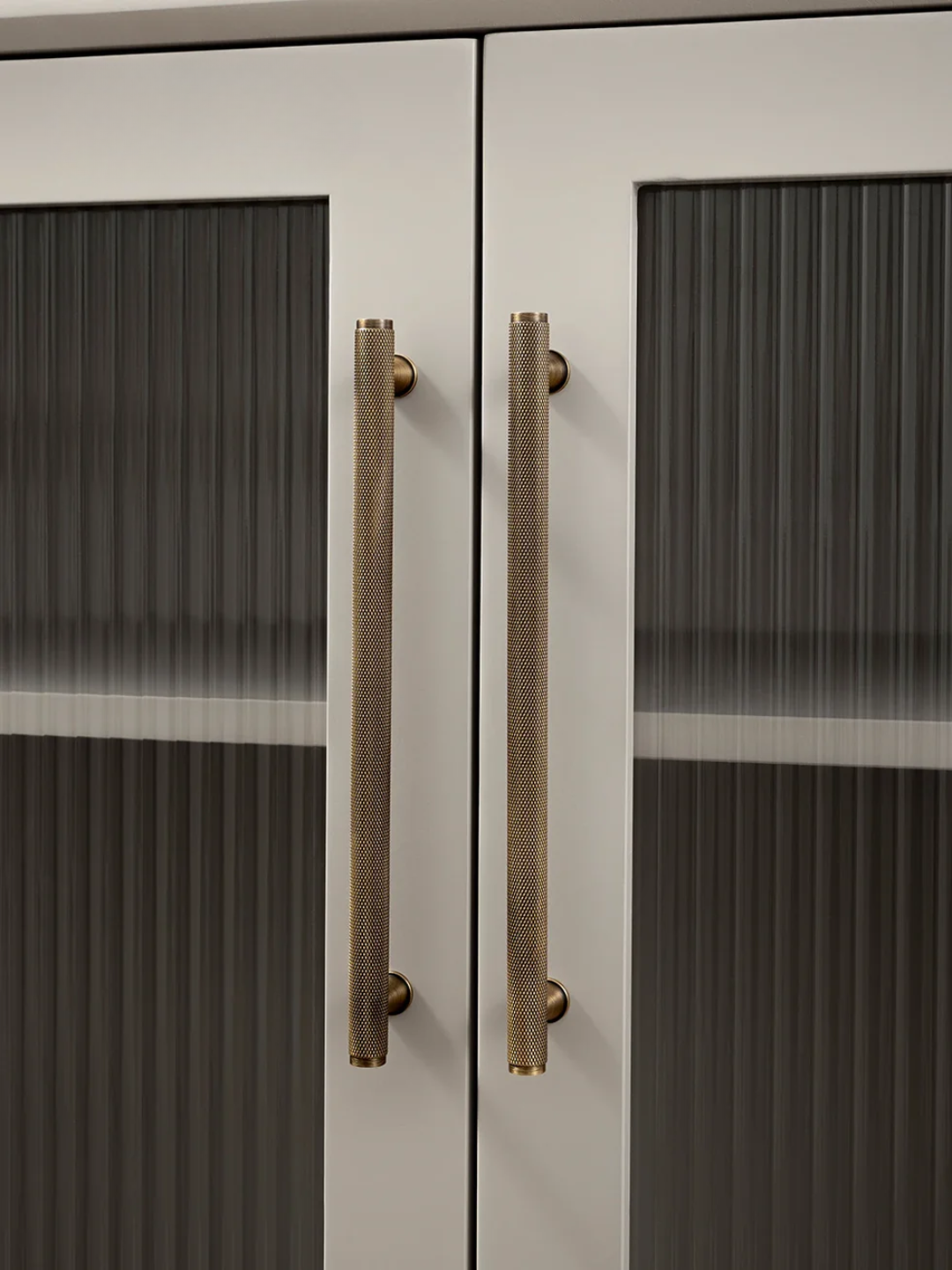 Close-up of a cabinet with glass doors and bronze handles