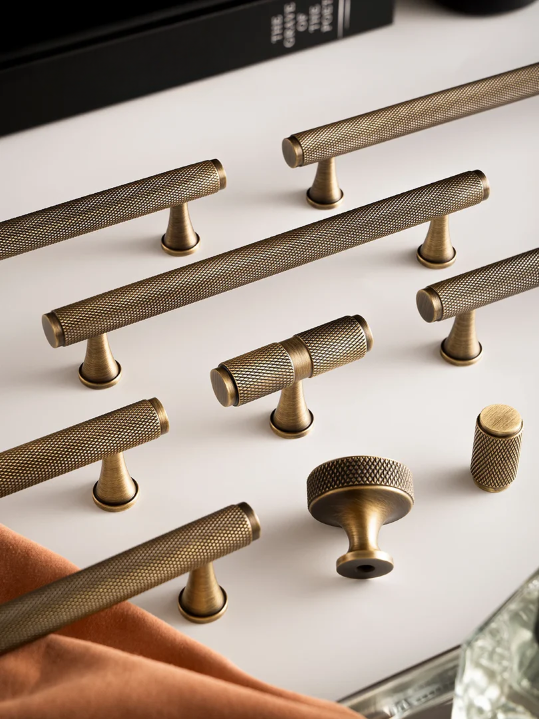 Collection of gold cabinet knobs on a white surface