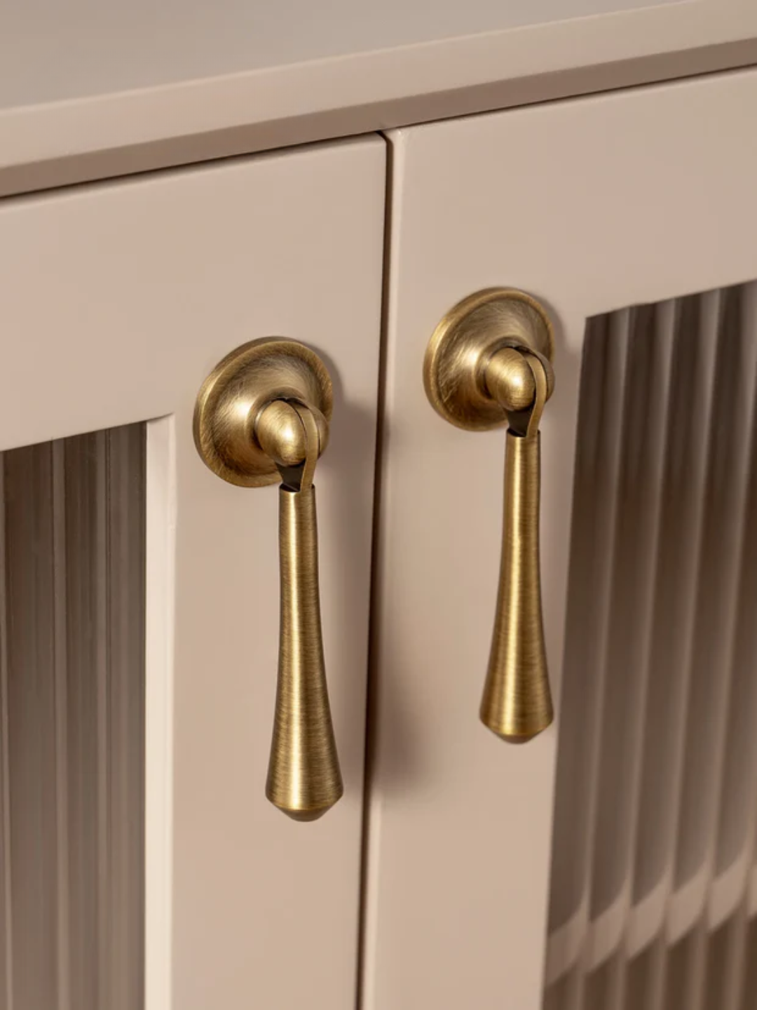 Close-up of beige cabinet doors with gold handles
