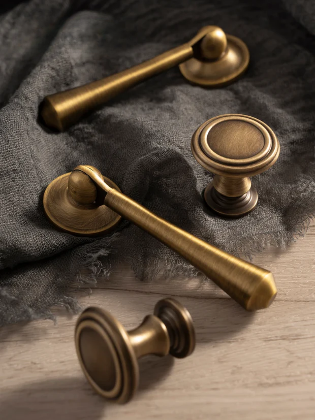 Set of brass cabinet handles on a textured fabric background