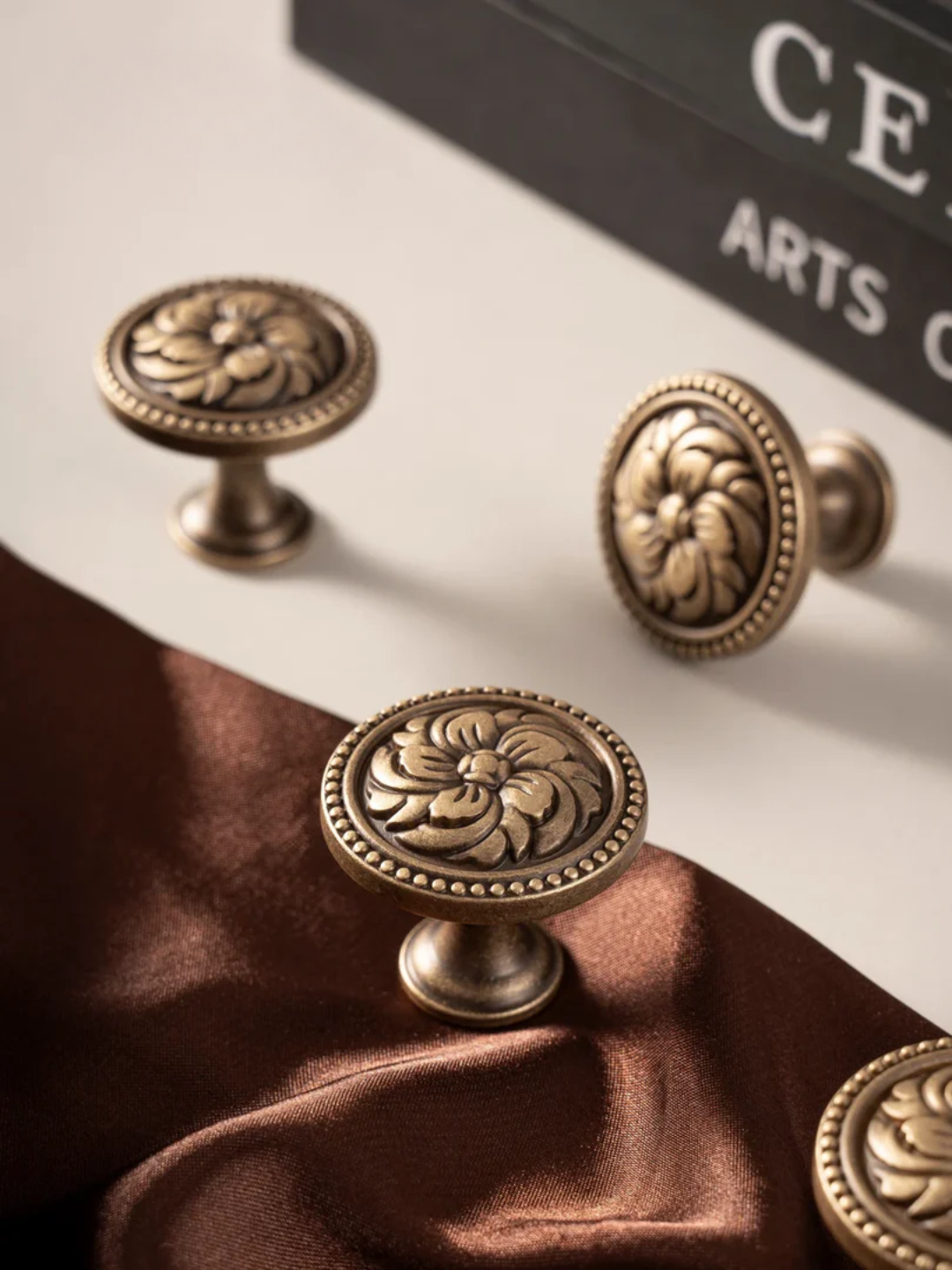 Decorative bronze knobs on a fabric surface with a blurred background
