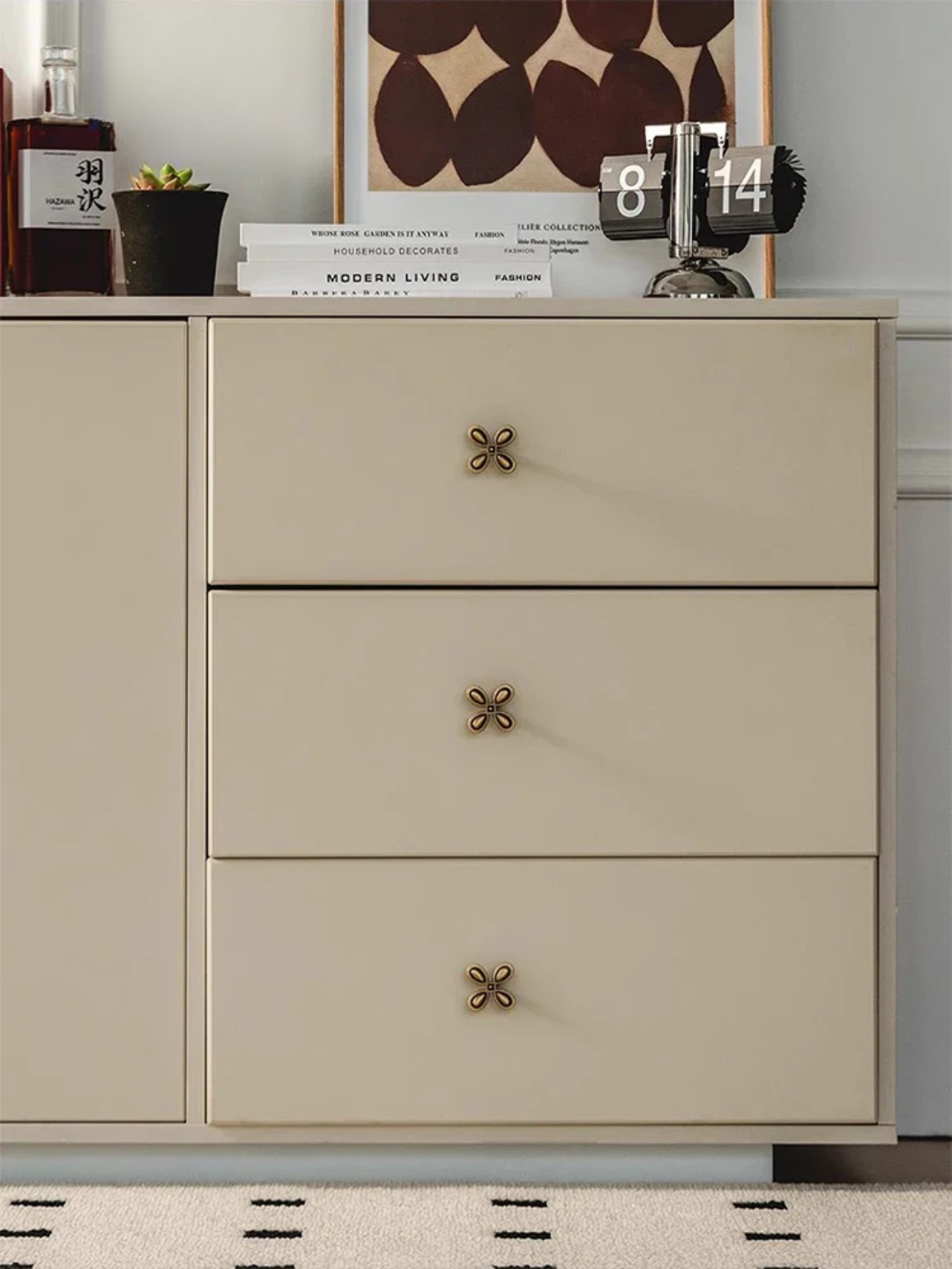 Beige dresser with two drawers and decorative handles in a room setting.