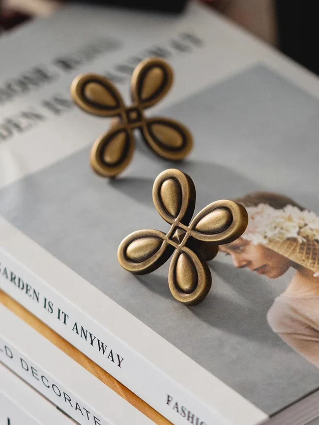 Pair of gold butterfly-shaped earrings on a magazine