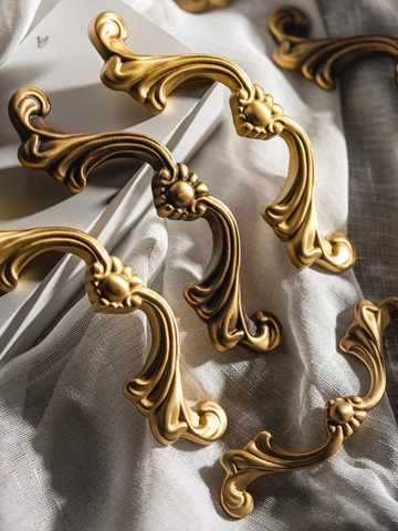 Decorative gold cabinet handles on a light fabric background