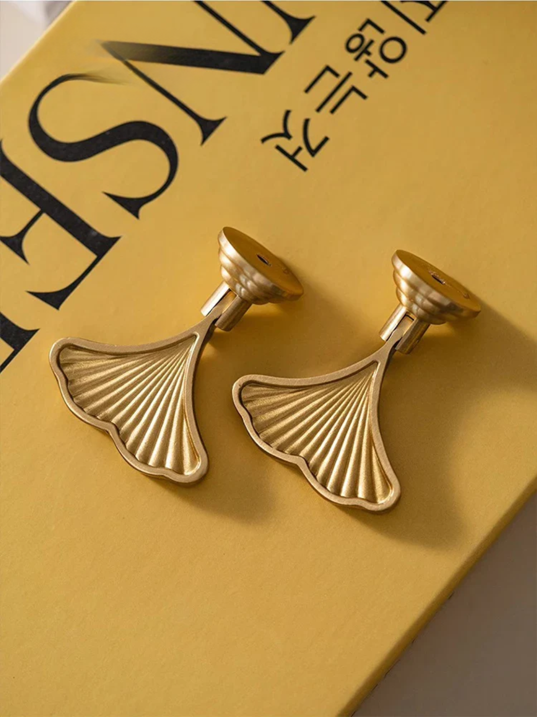 Gold leaf-shaped handles on a yellow surface with text