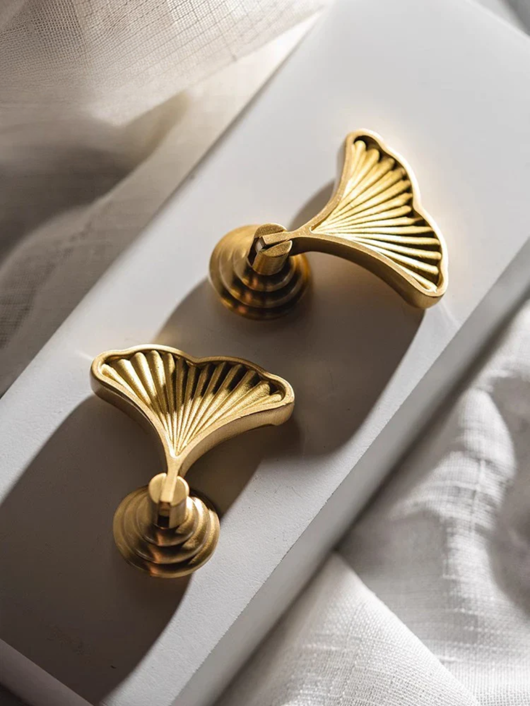 Gold door handles on a white door with a textured background
