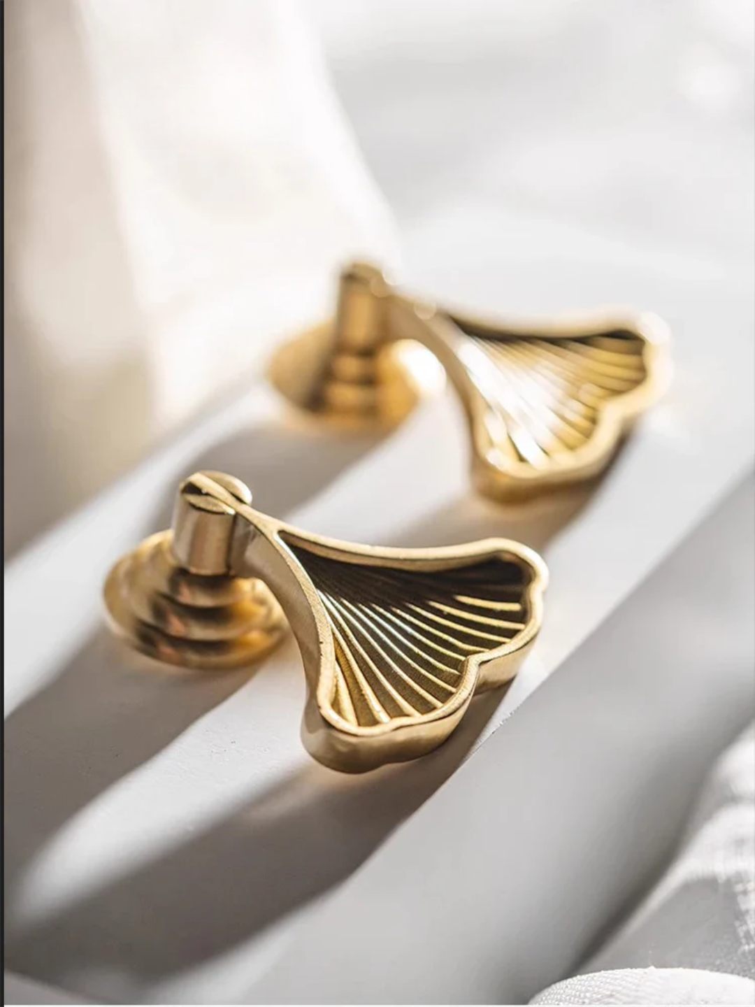 Gold leaf-shaped handles on a light background