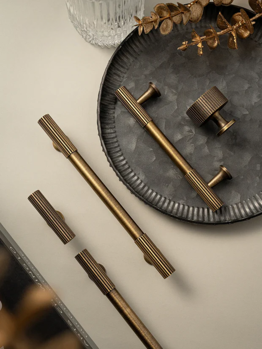 Set of bronze cabinet handles on a decorative plate with a neutral background