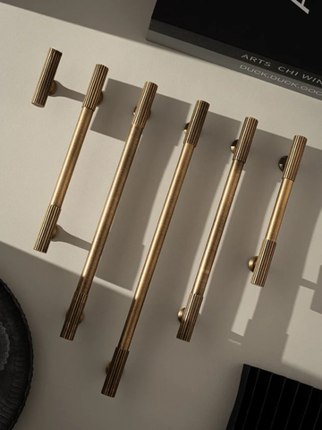 Set of gold cabinet handles on a light surface