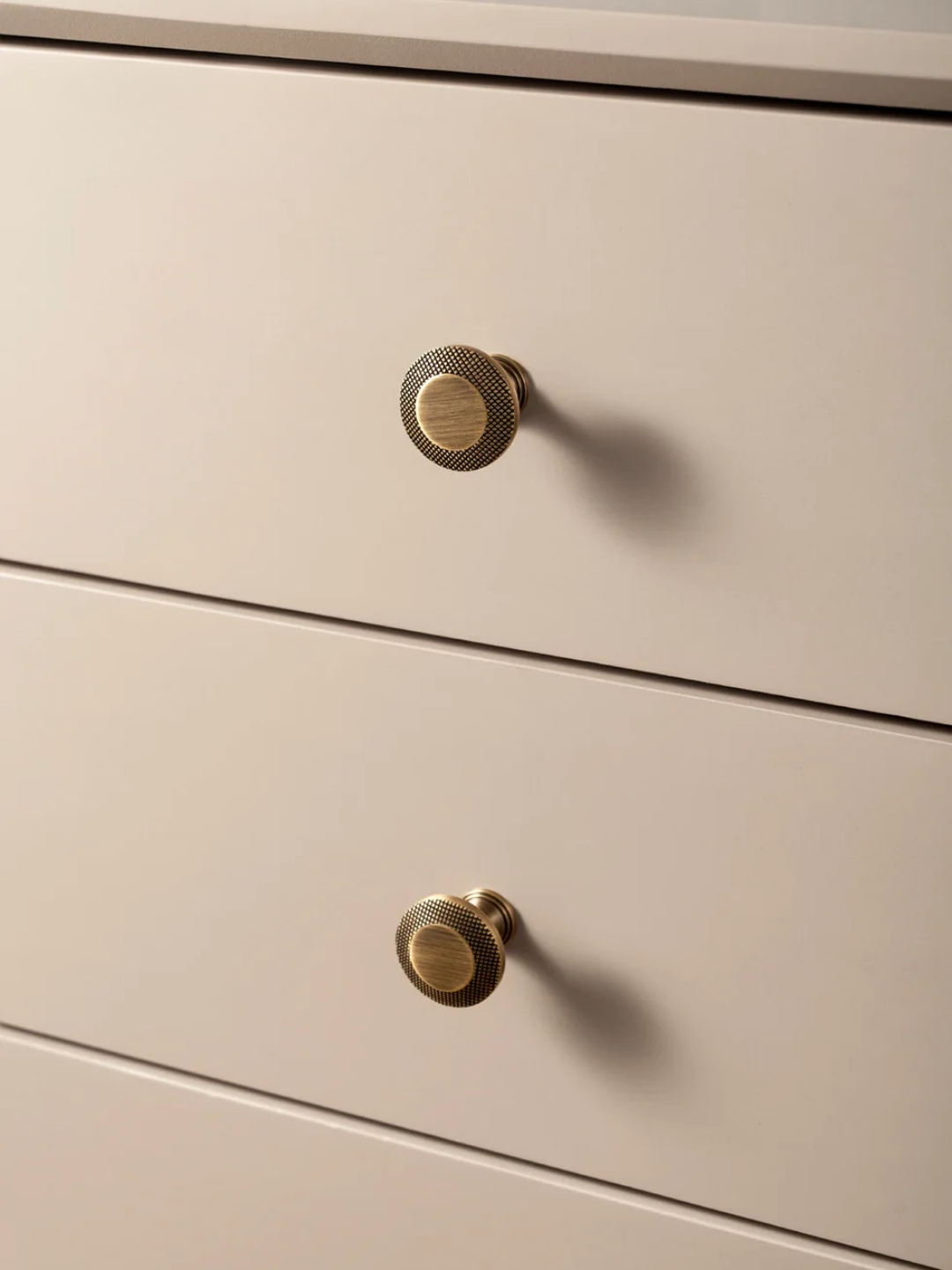 Close-up of beige drawers with gold knobs