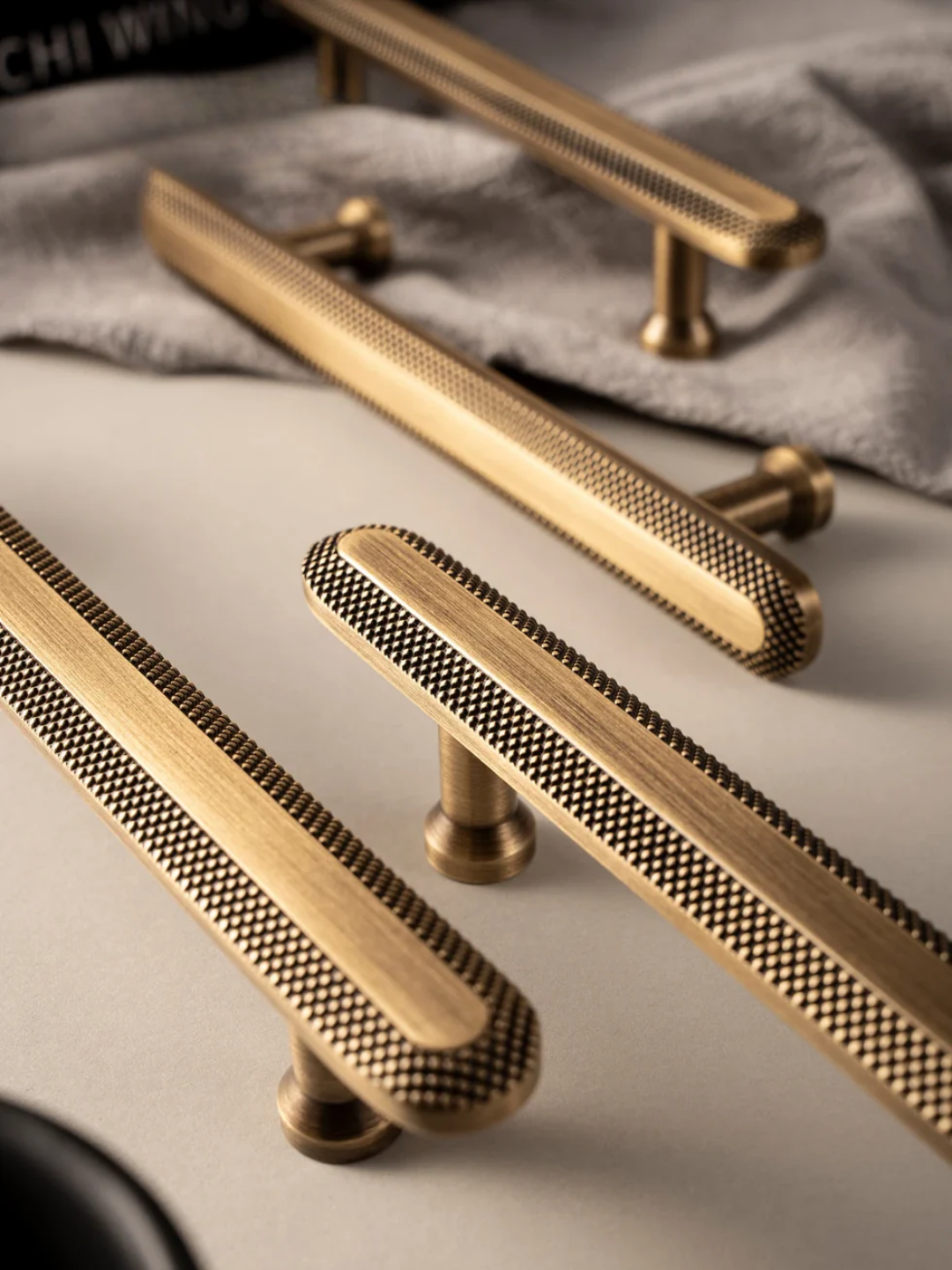 Gold cabinet handles with textured design on a neutral background