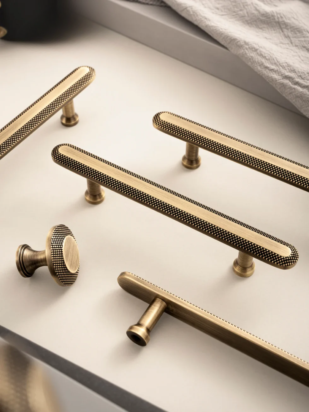 Set of gold cabinet handles on a light gray surface