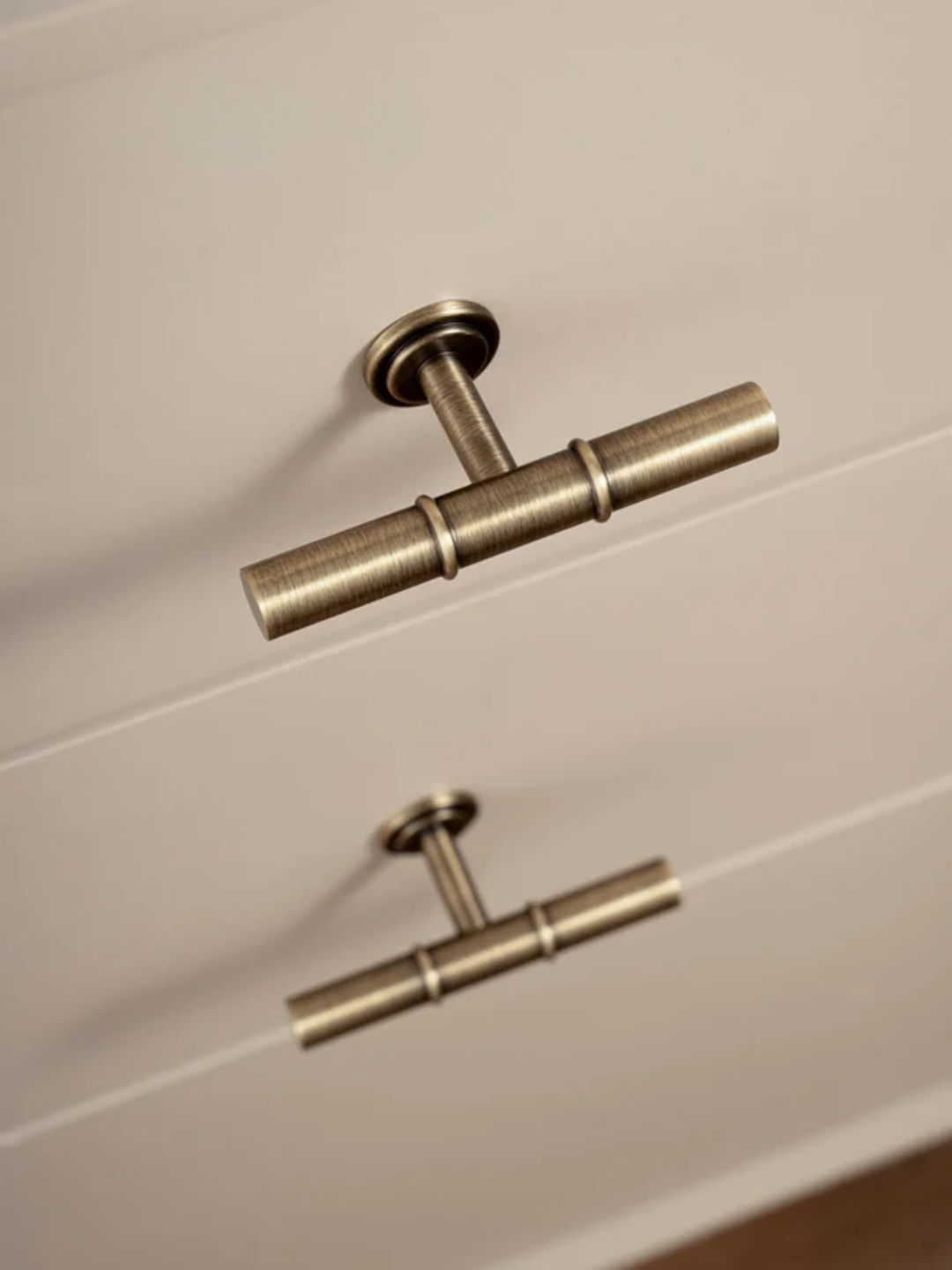 Brass cabinet handles on a white wooden drawer