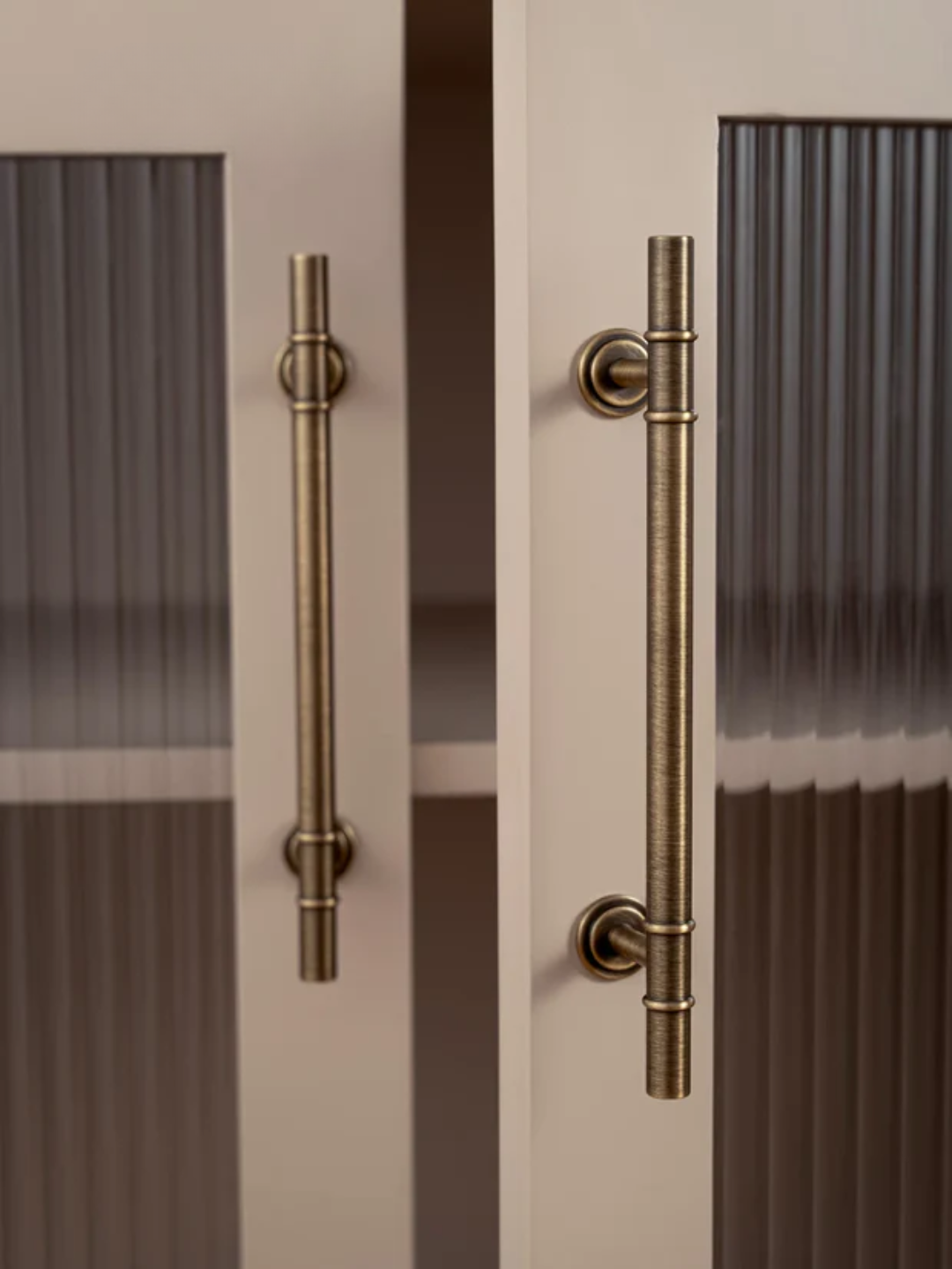 Close-up of a door with bronze handles on a neutral background