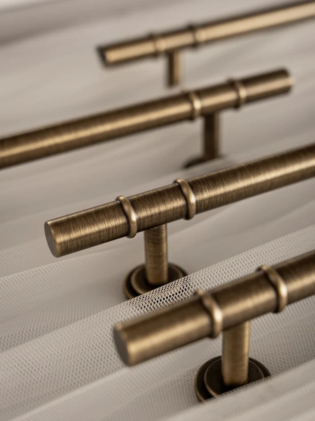Brass cabinet handles on a textured surface with 'Santaya' branding.