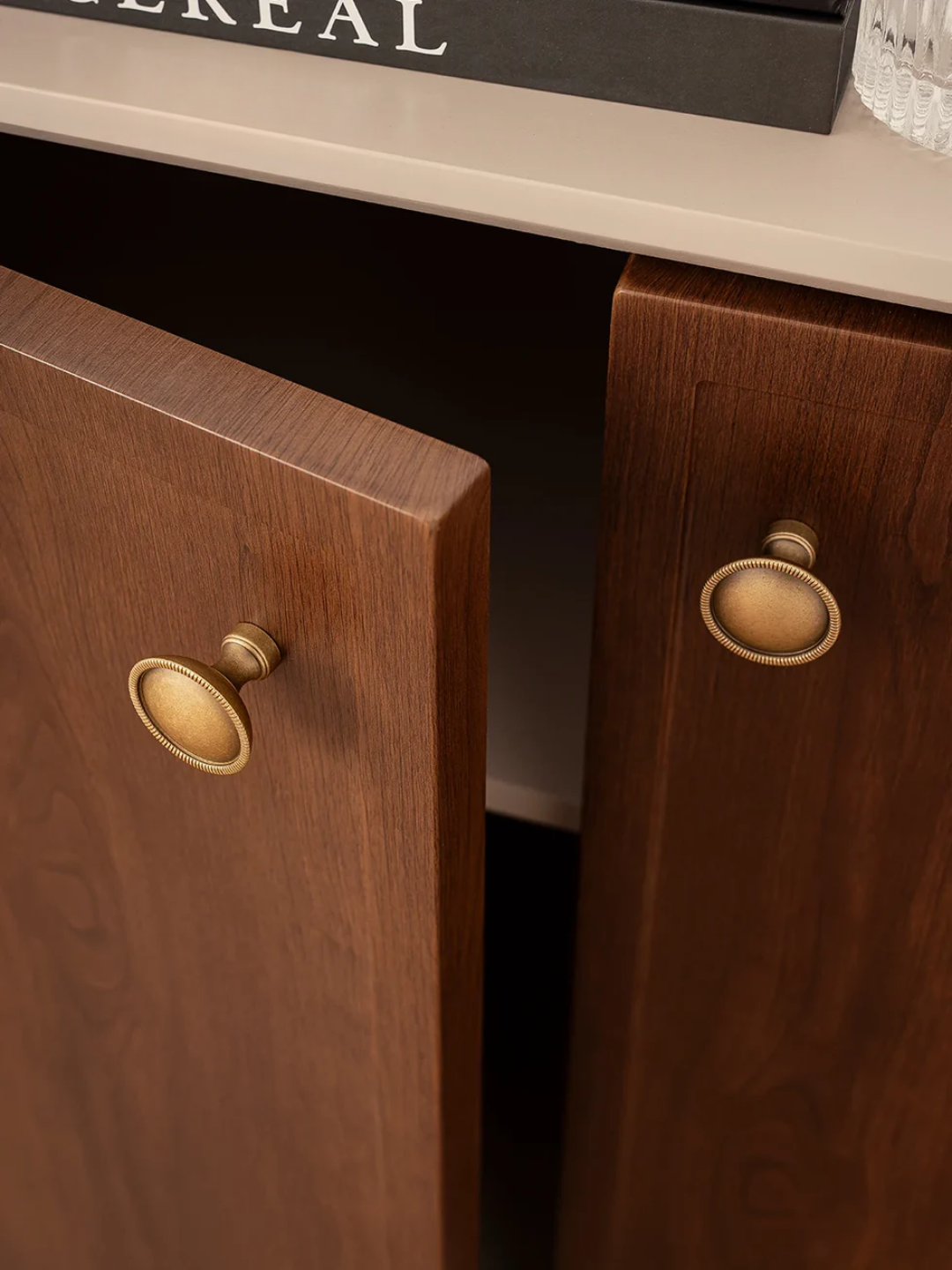 Wooden cabinets with brass handles on a kitchen counter.