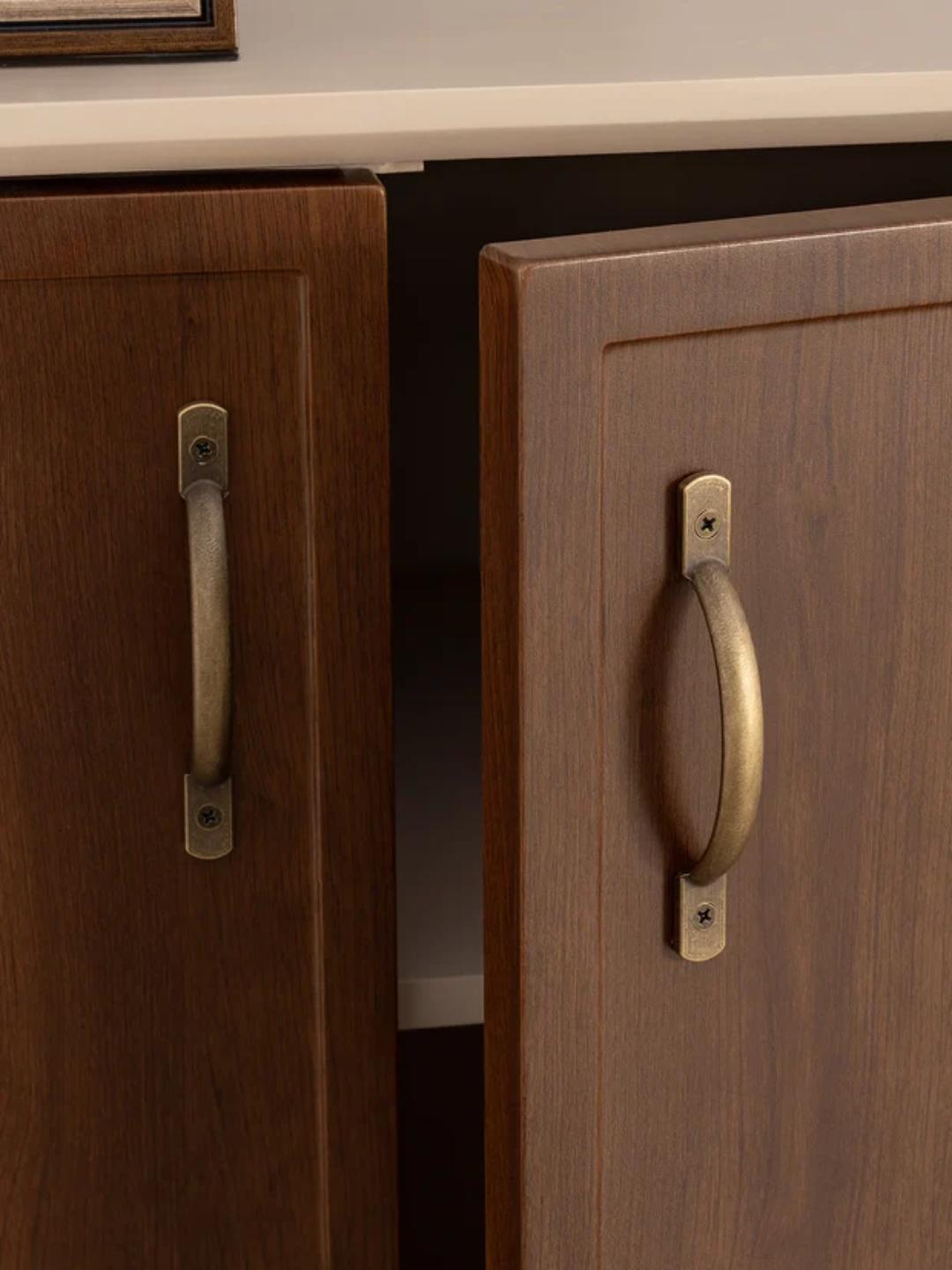 Wooden cabinets with brass handles on a neutral background