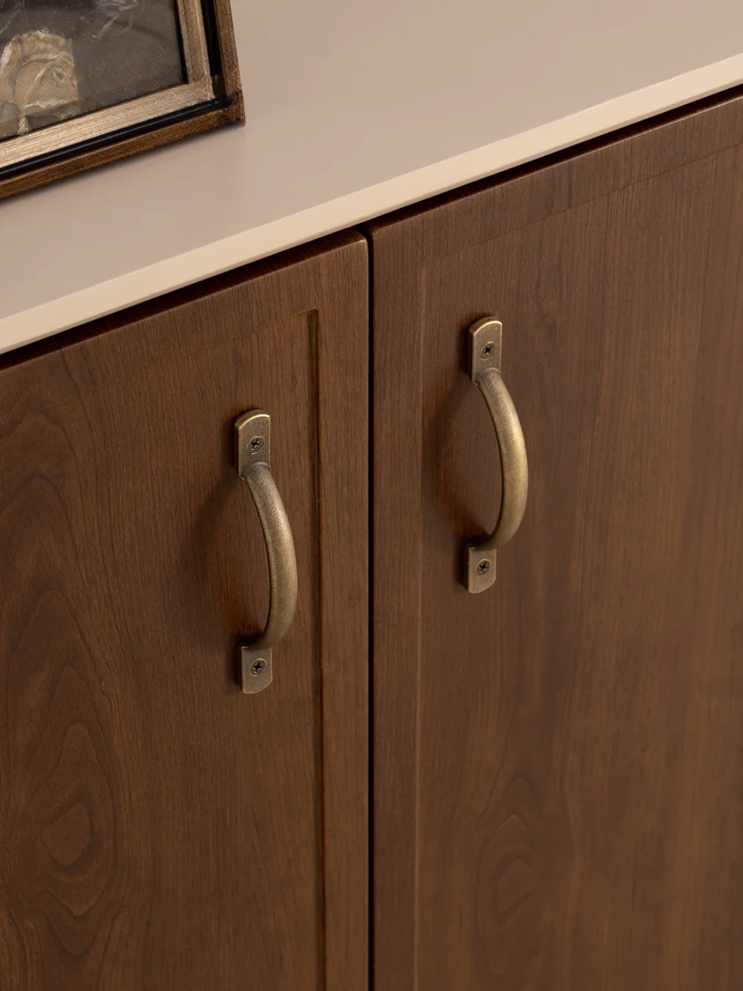 Wooden cabinet with brass handles on a neutral background