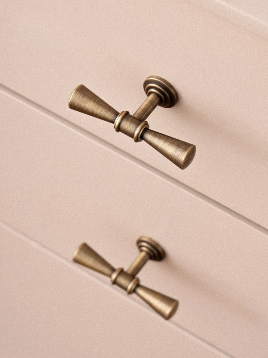 Brass cabinet knobs on a pink cabinet