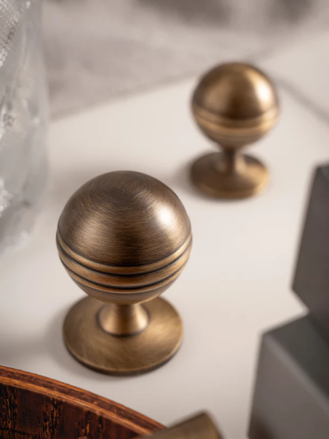Two bronze cabinet knobs on a textured surface