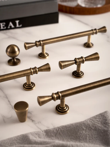 Collection of bronze cabinet handles on a marble surface