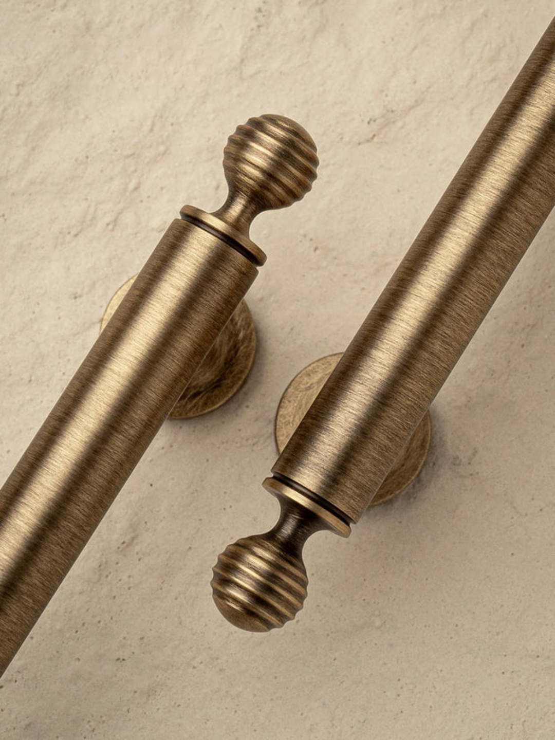 Pair of gold curtain rods with decorative finials on a beige background, branded 'Santaya'.