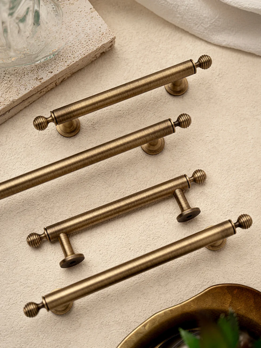 Set of gold cabinet handles on a textured surface with 'Santaya' branding.