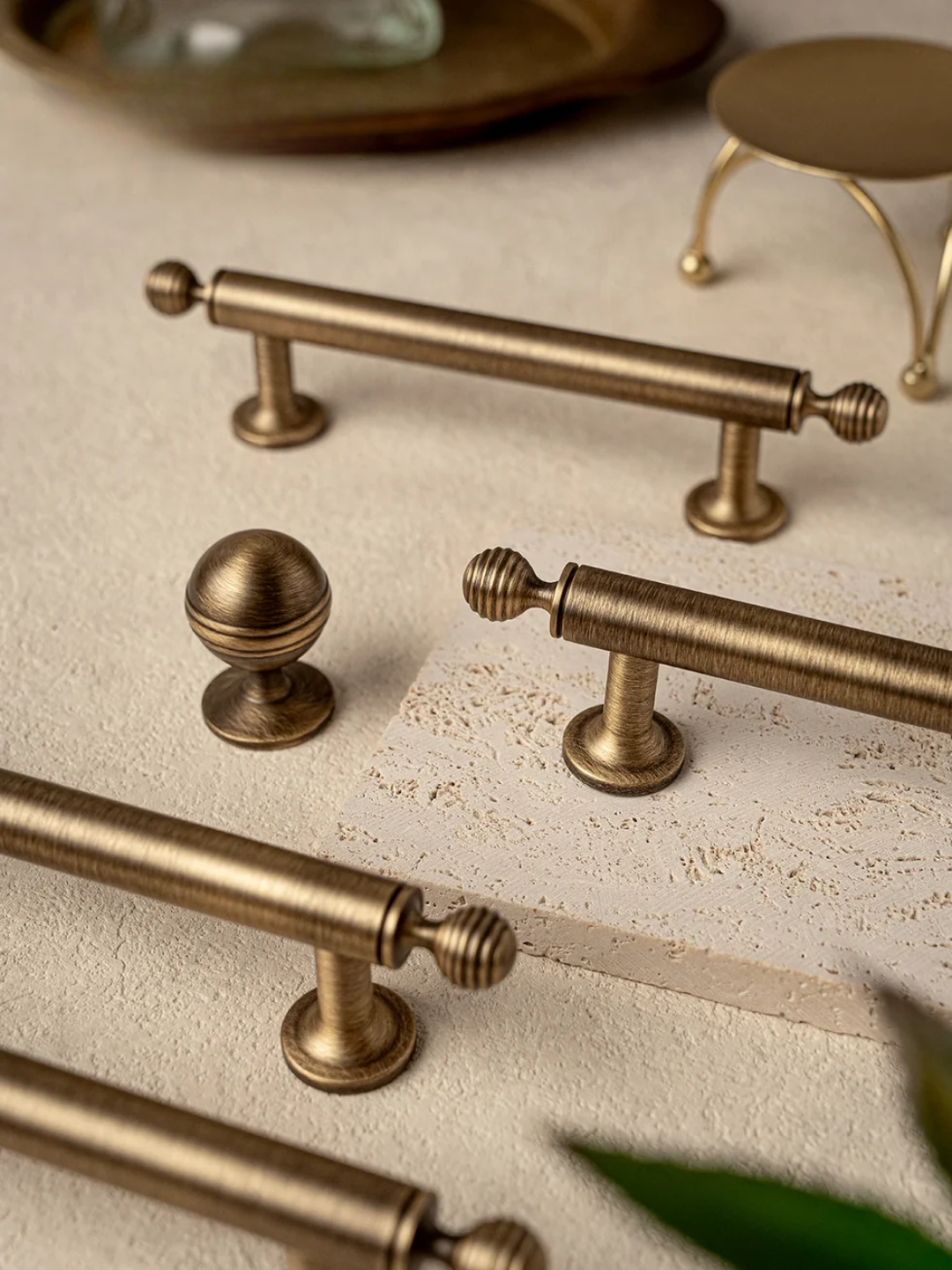 Collection of brass cabinet handles on a textured surface