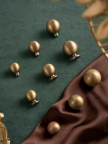 Bronze knobs on a green and brown fabric background
