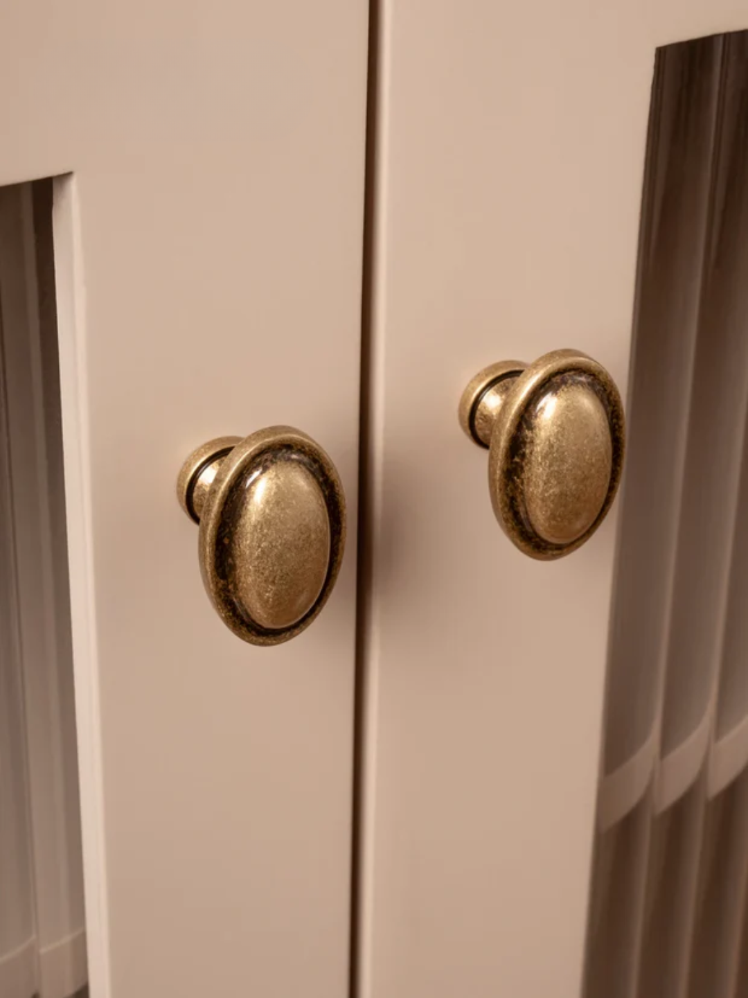 Close-up of a beige cabinet with gold knobs