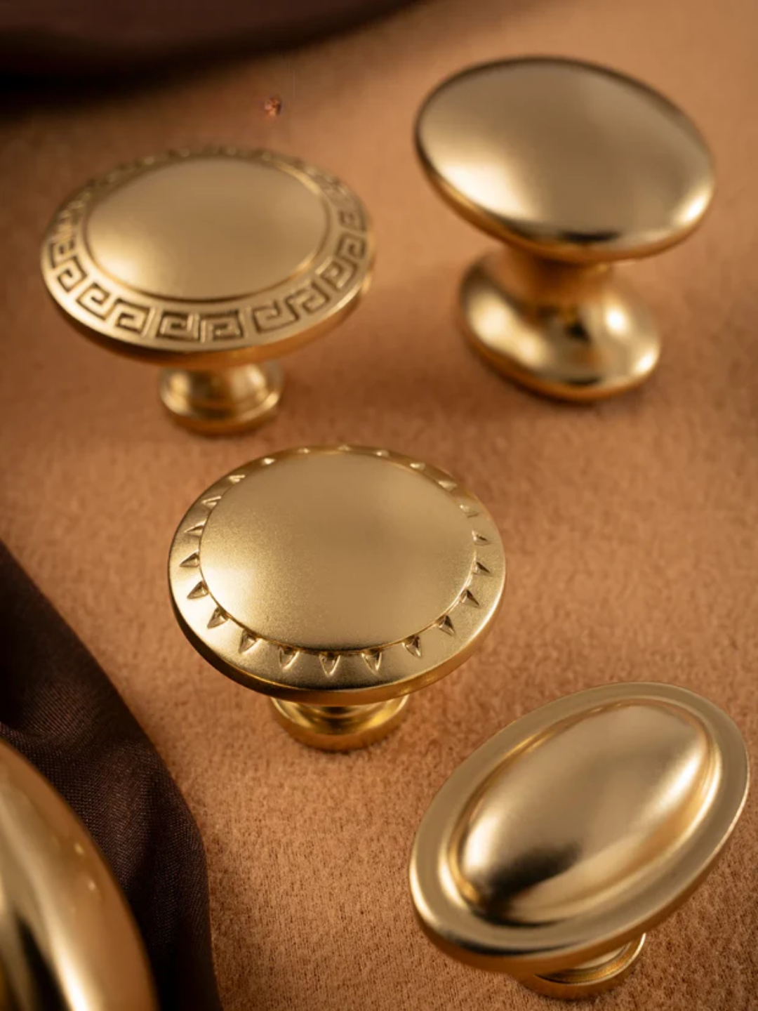 Set of gold cabinet knobs on a brown surface