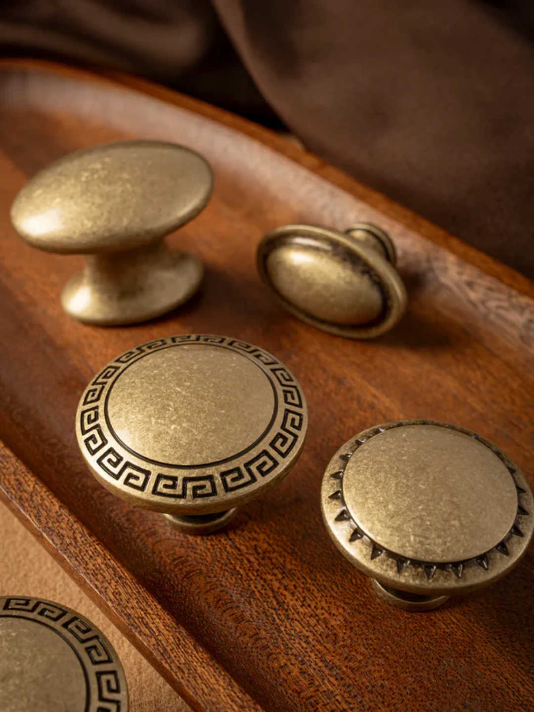 Set of brass cabinet knobs on a wooden surface