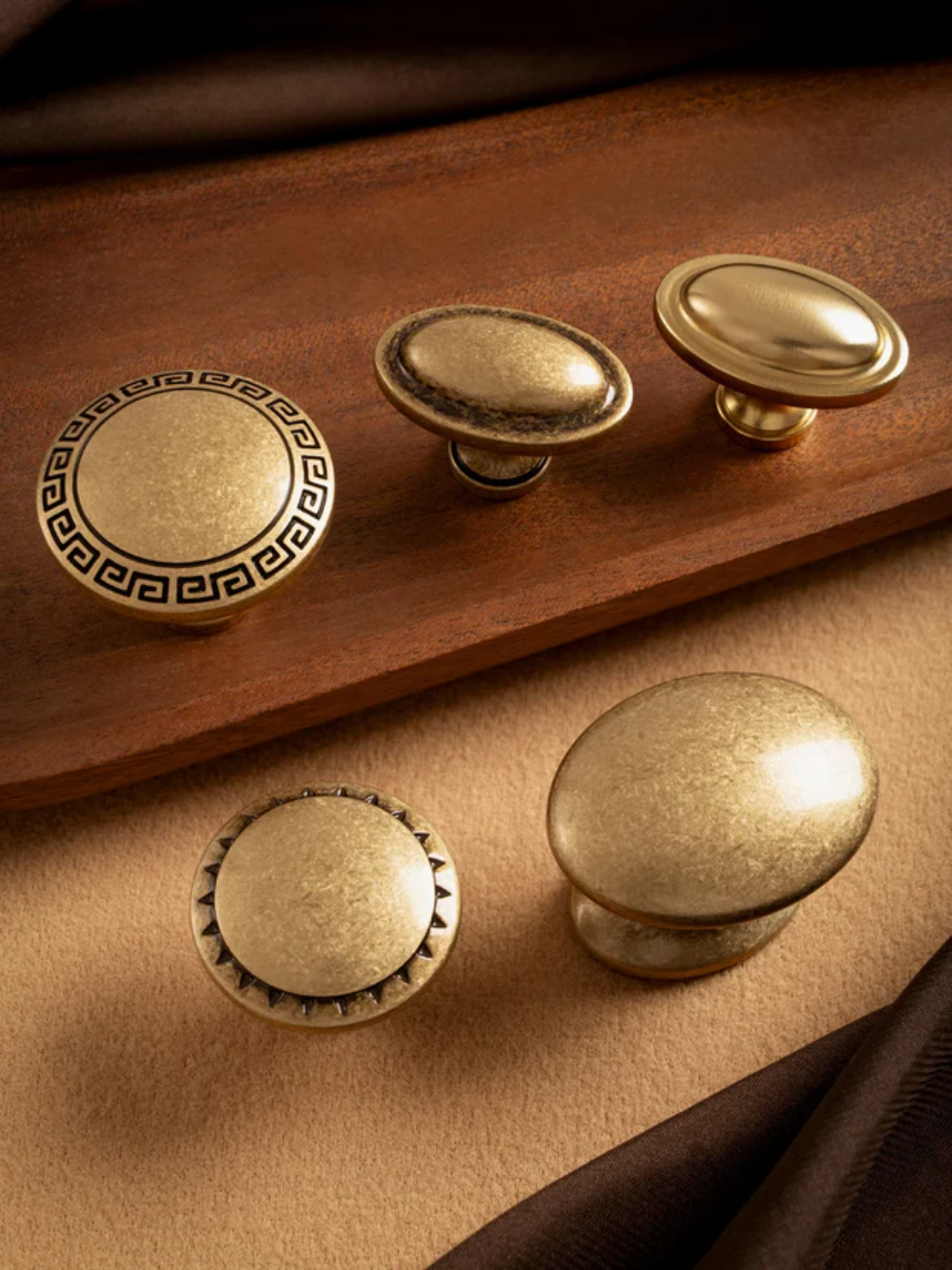Set of brass cabinet knobs on a wooden and leather surface