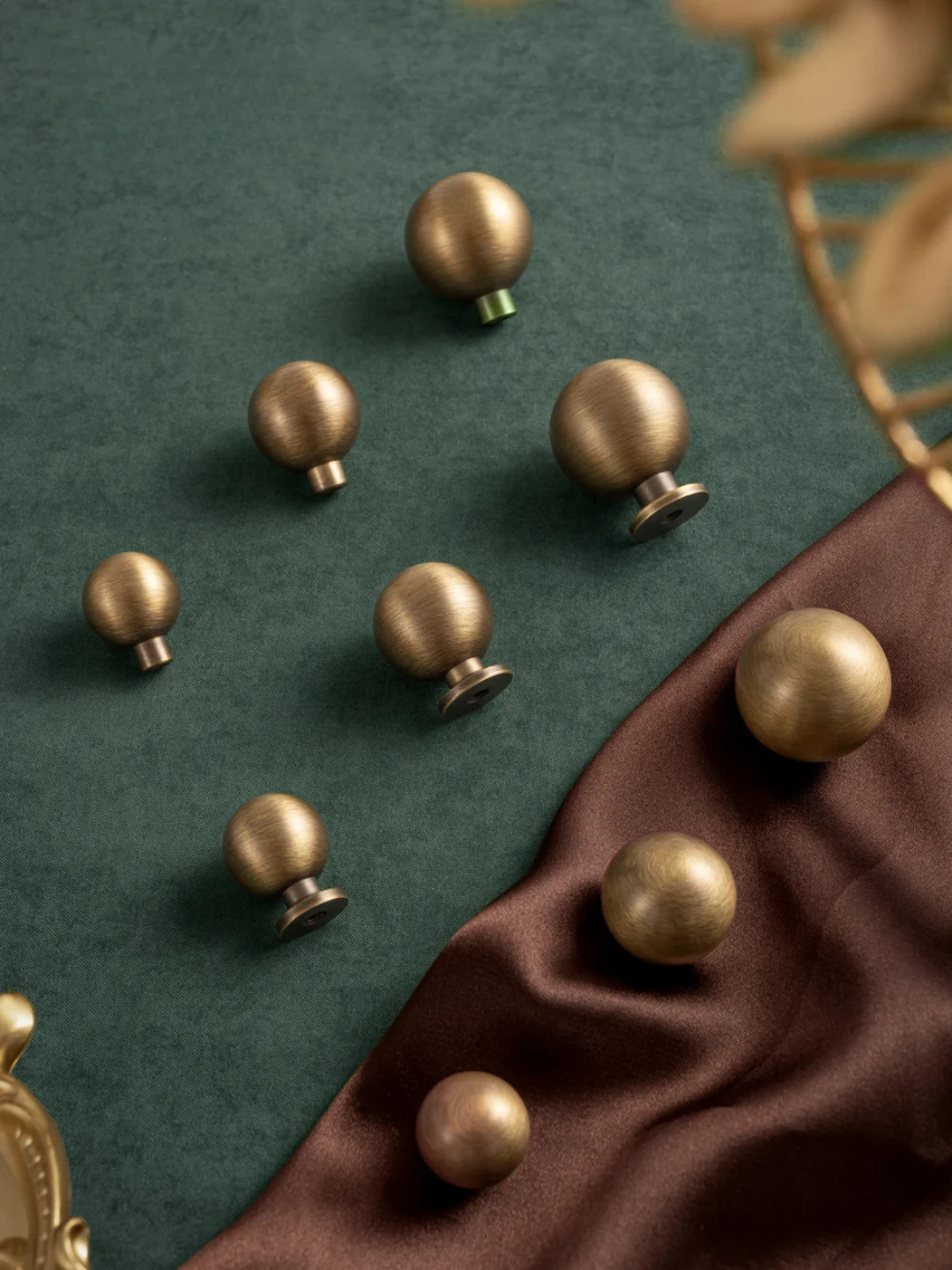 Bronze knobs on a green and brown fabric background