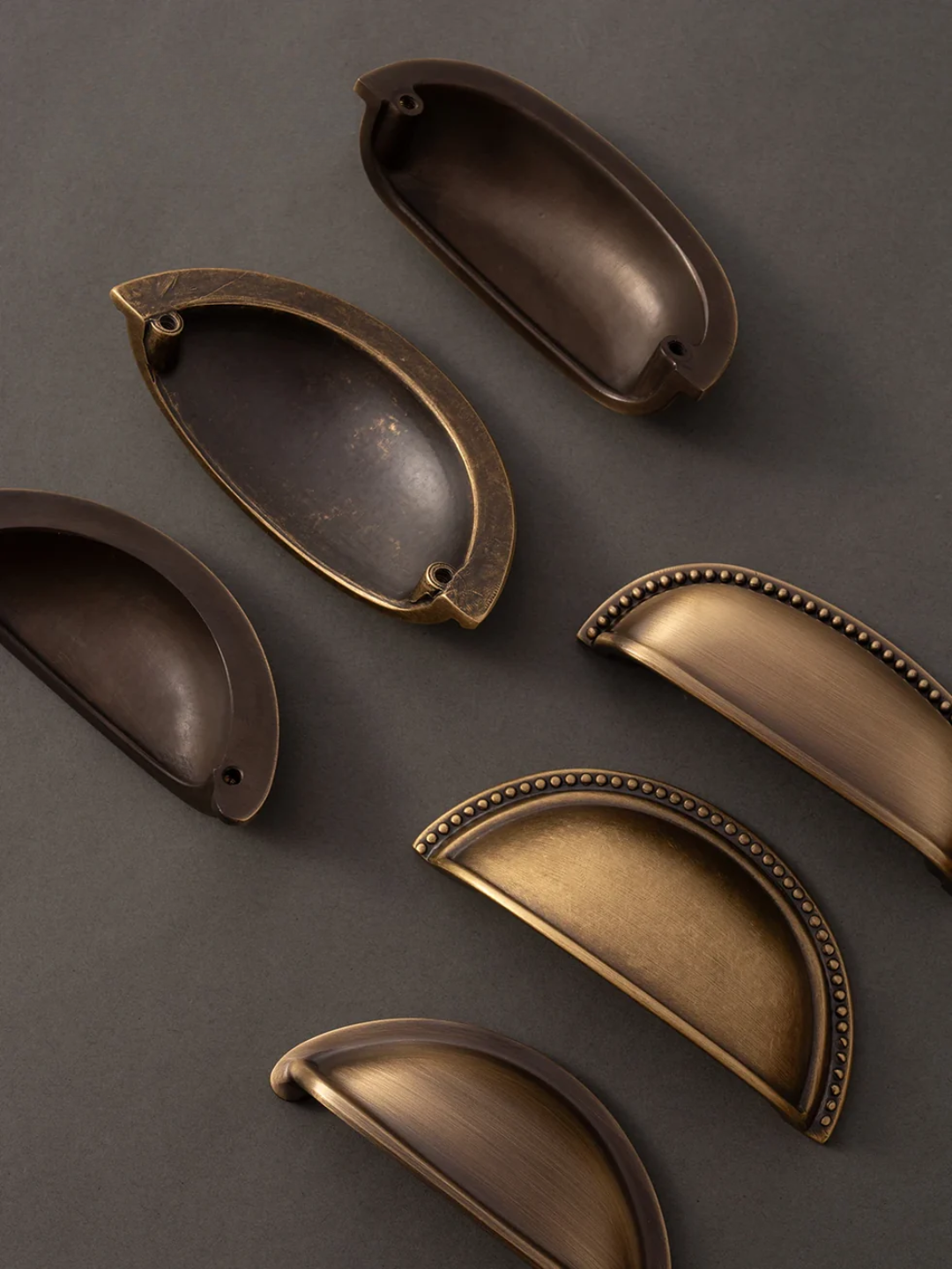 Set of bronze cabinet handles on a dark gray background