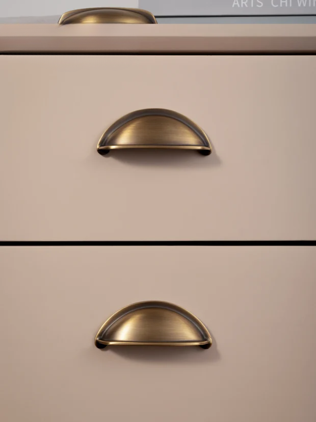Close-up of a beige cabinet with bronze handles