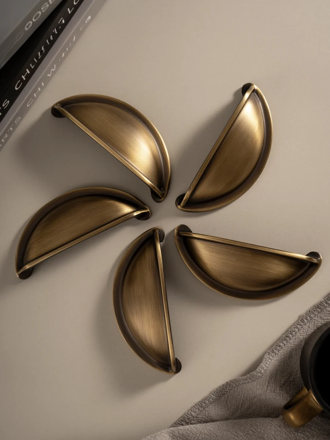 Set of five gold decorative half-circle objects on a neutral background