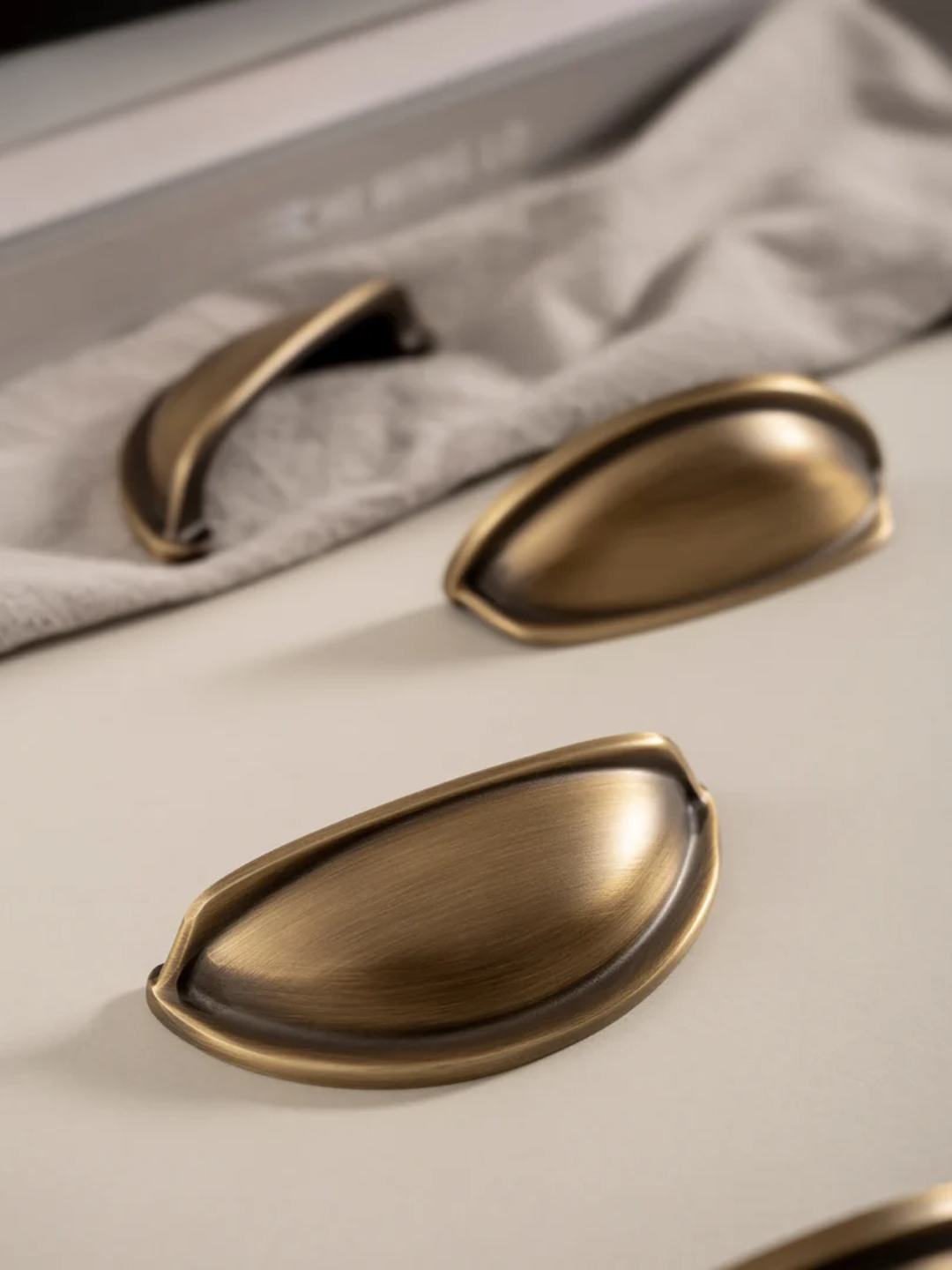 Close-up of bronze cabinet handles on a light-colored surface.