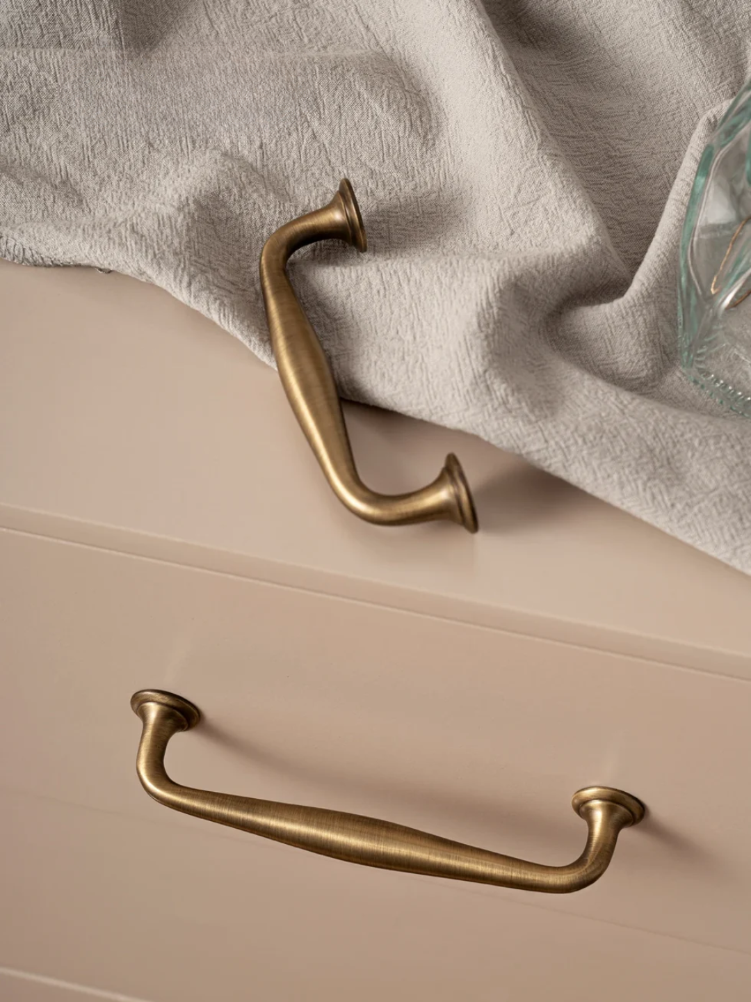 Beige drawer with gold handles on a neutral background