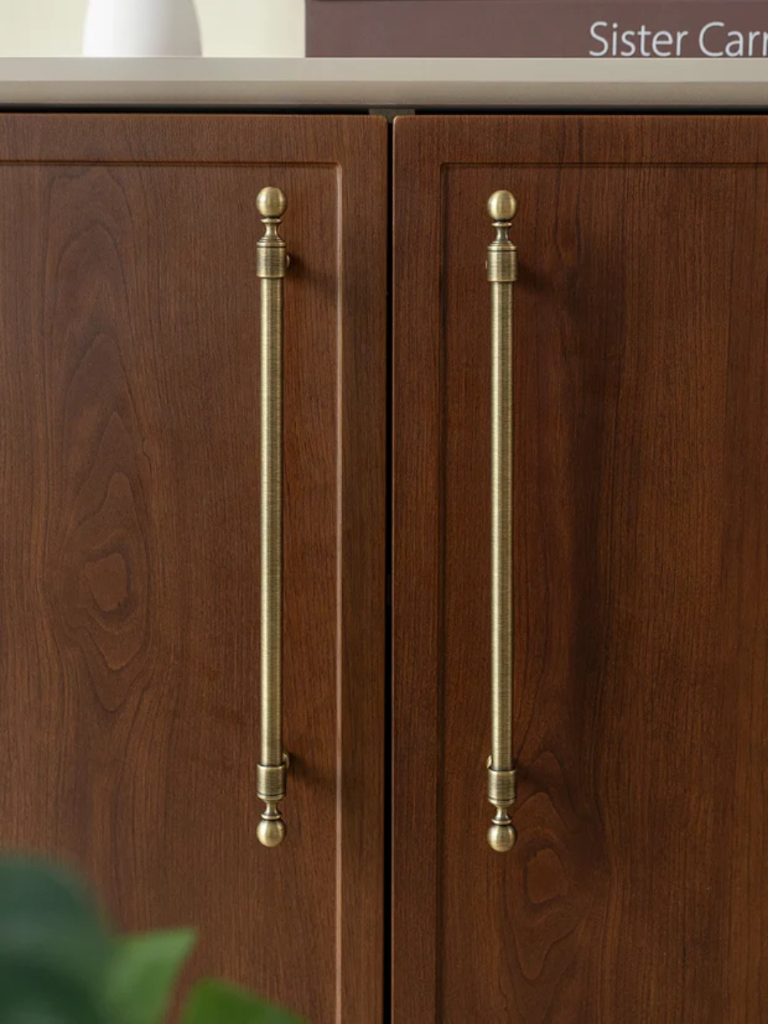 Wooden cabinet with brass handles on a neutral background