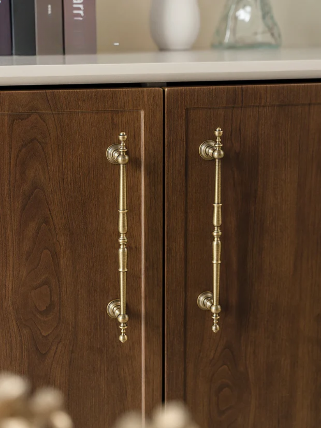 Wooden cabinet with brass handles on a neutral background