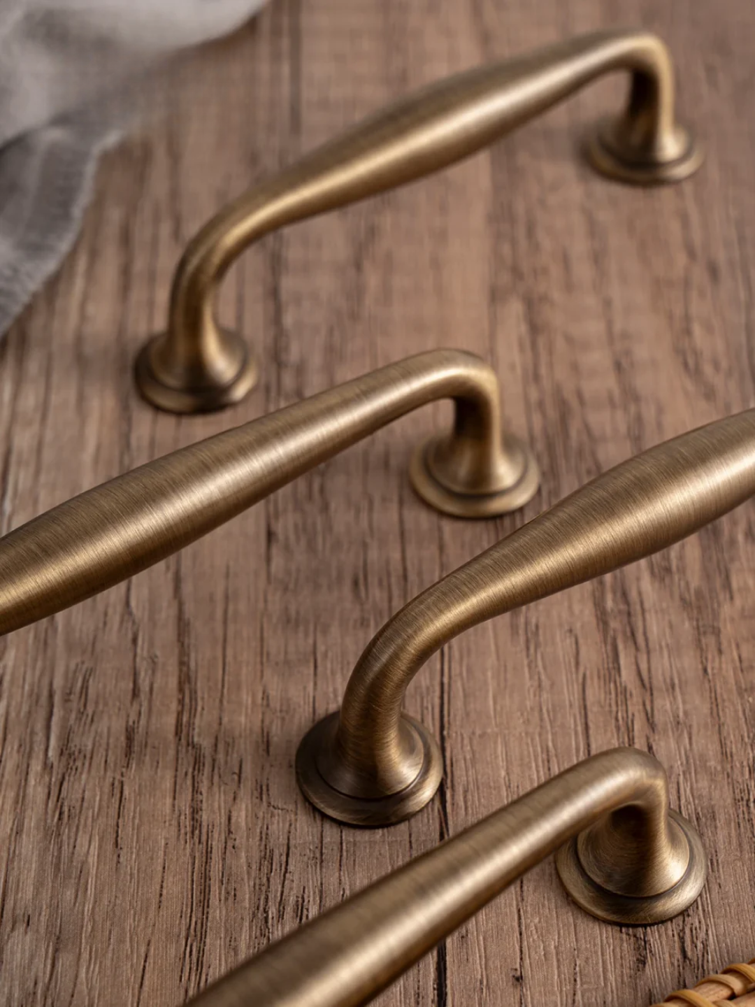 Set of brass cabinet handles on a textured fabric surface