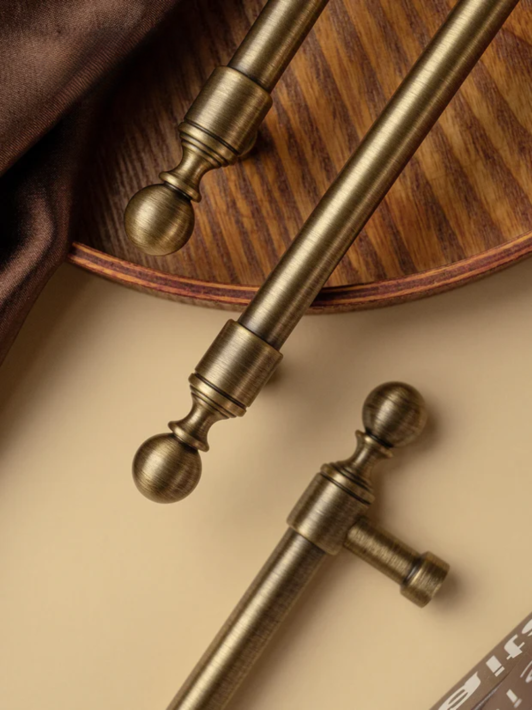 Close-up of decorative curtain rods with spherical finials on a wooden surface.
