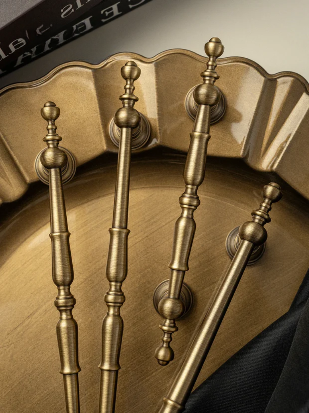 Set of gold cabinet handles on a decorative tray