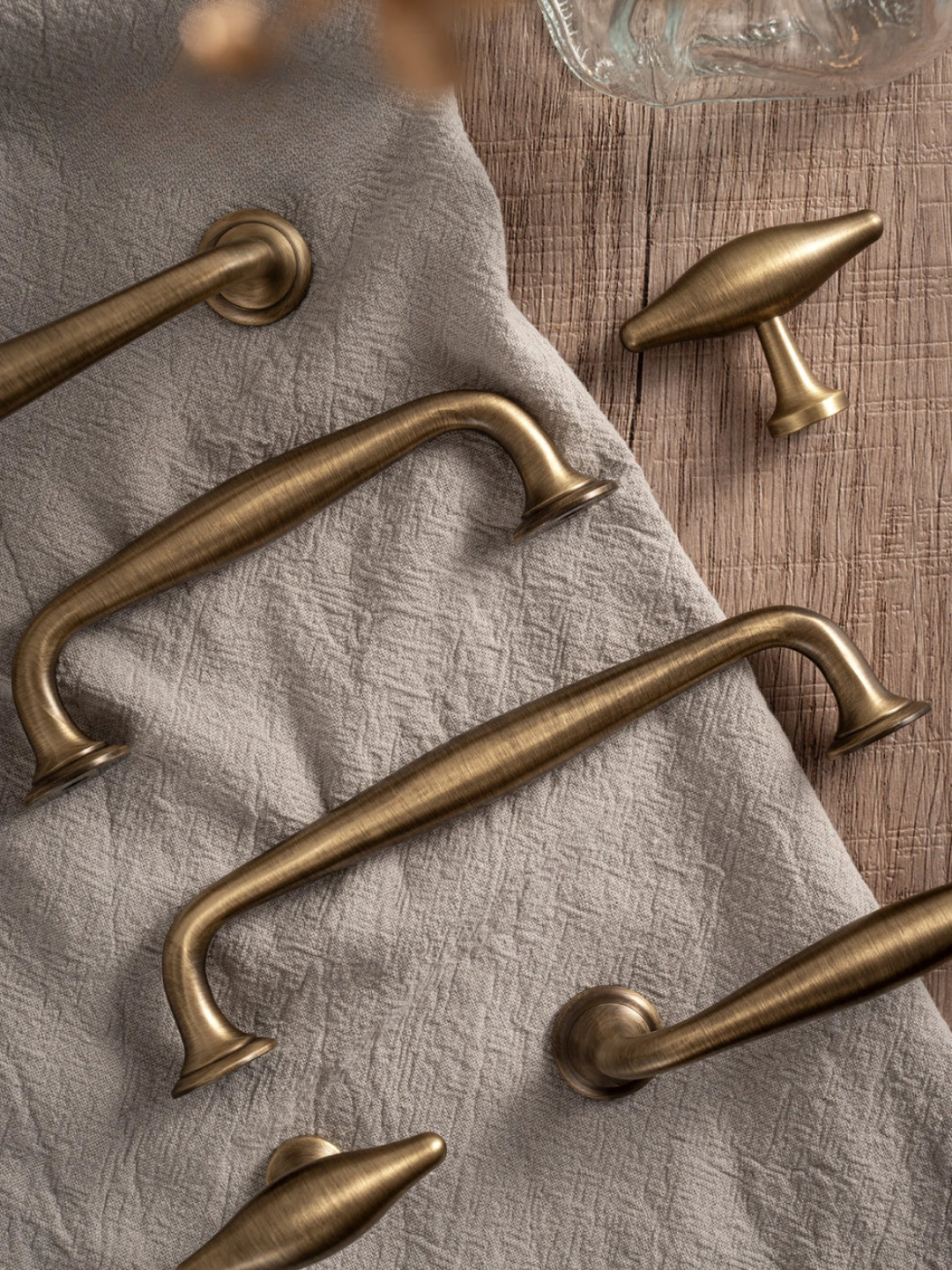 Set of brass cabinet handles on a textured fabric surface