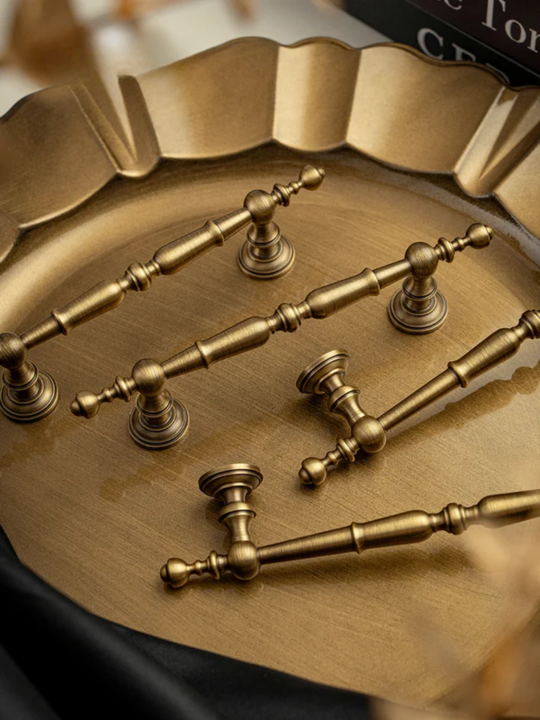 Set of gold cabinet handles on a decorative tray