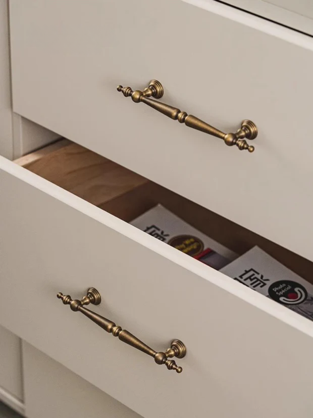 Set of vintage-style brass cabinet handles on a dark background