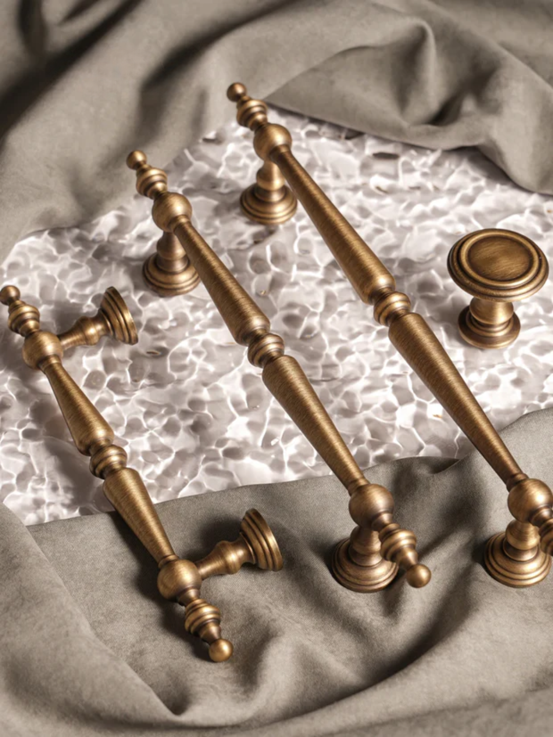 Set of vintage-style brass cabinet handles on a textured surface