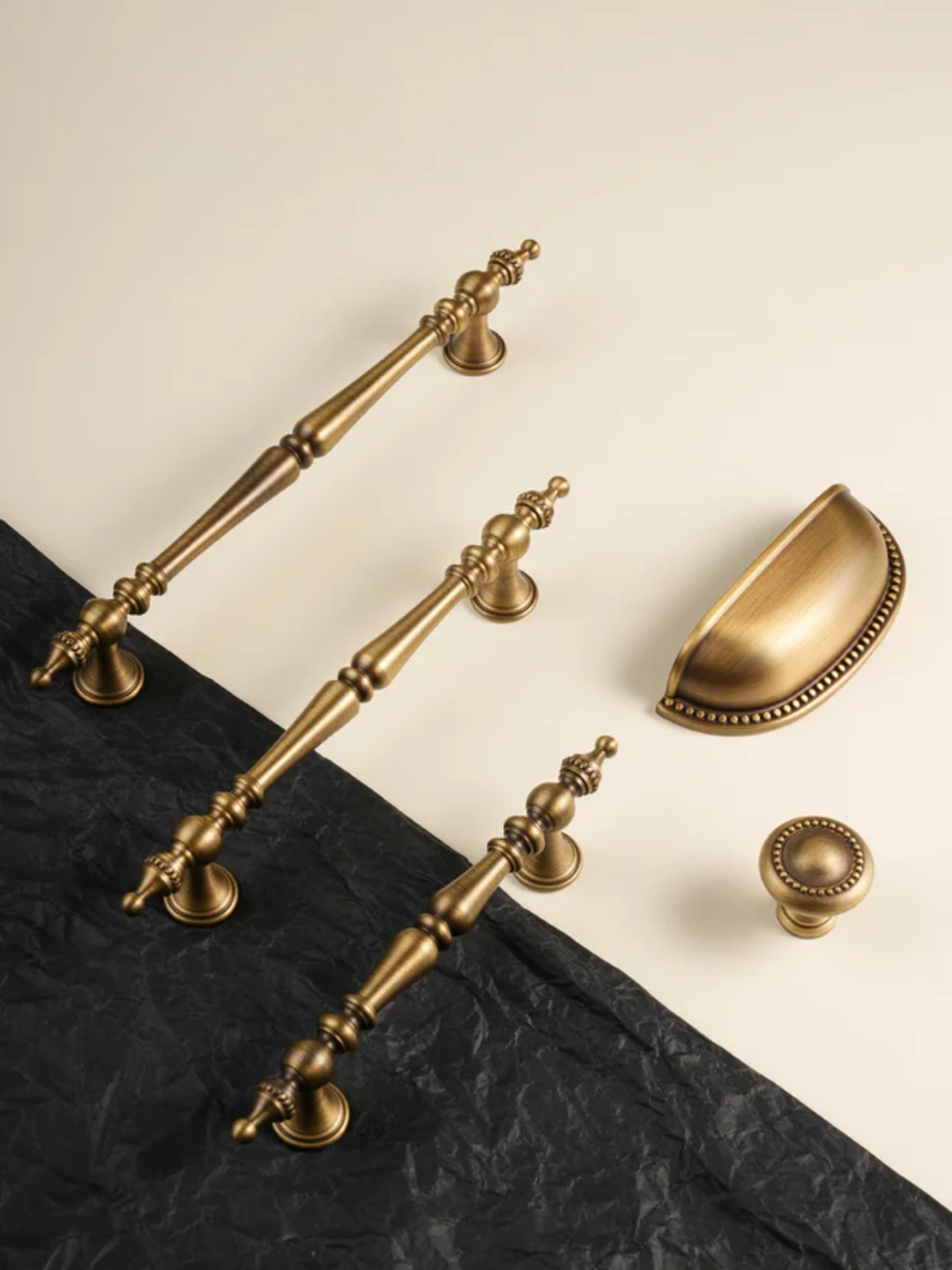 Collection of vintage-style brass hardware on a black and beige background