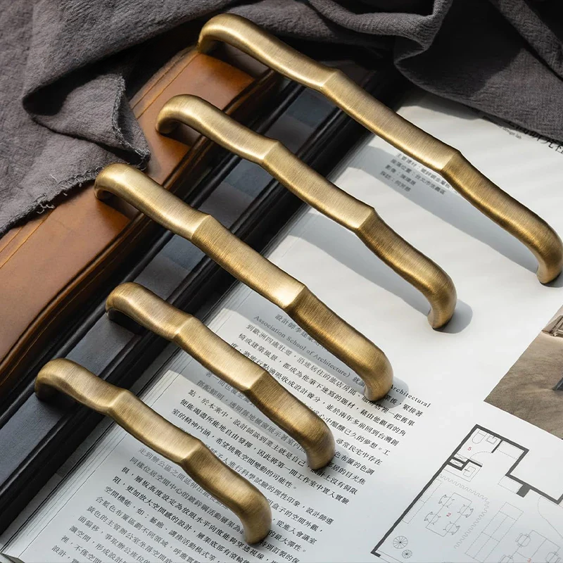 Set of bronze door handles on a surface with a newspaper underneath